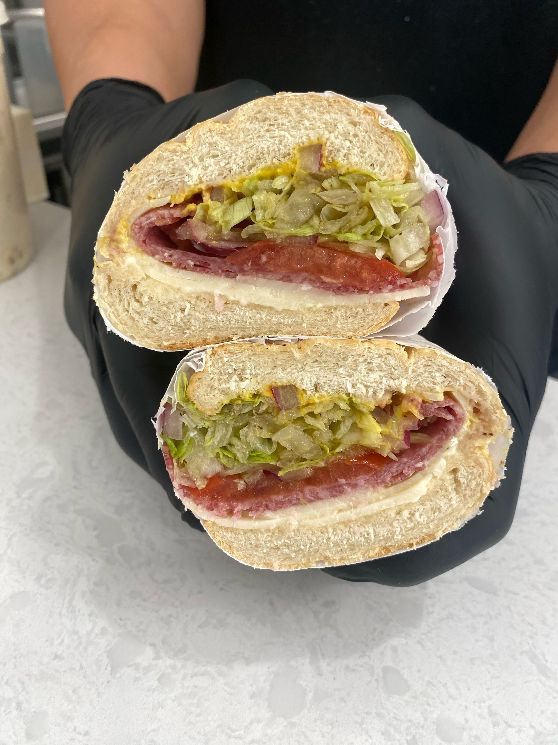 Close-up of Italian deli sandwich with meats, cheese, and fresh toppings