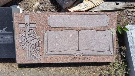 a gravestone with a cross and a bible on it