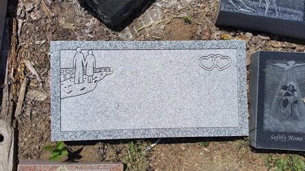 a gravestone with a picture of a city and a wedding ring on it .