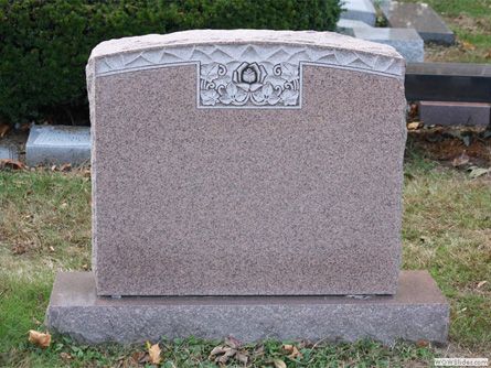 a gravestone in a cemetery with a rose on it
