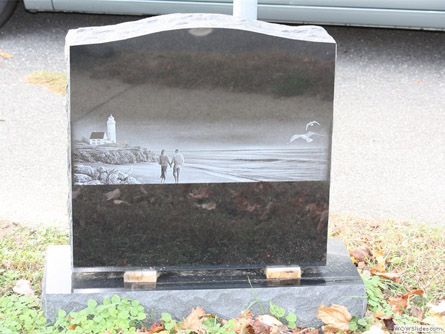 a gravestone with a picture of a lighthouse on it