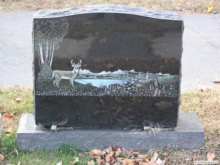a gravestone with a picture of a deer on it