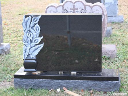 a black gravestone with a floral design on it