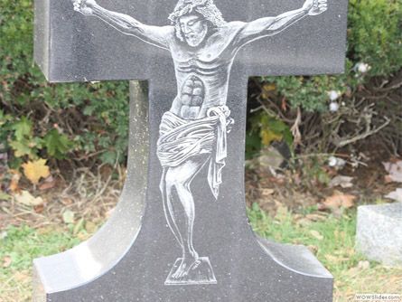 a gravestone with a statue of jesus on the cross