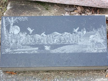 a gravestone with a picture of a moose on it
