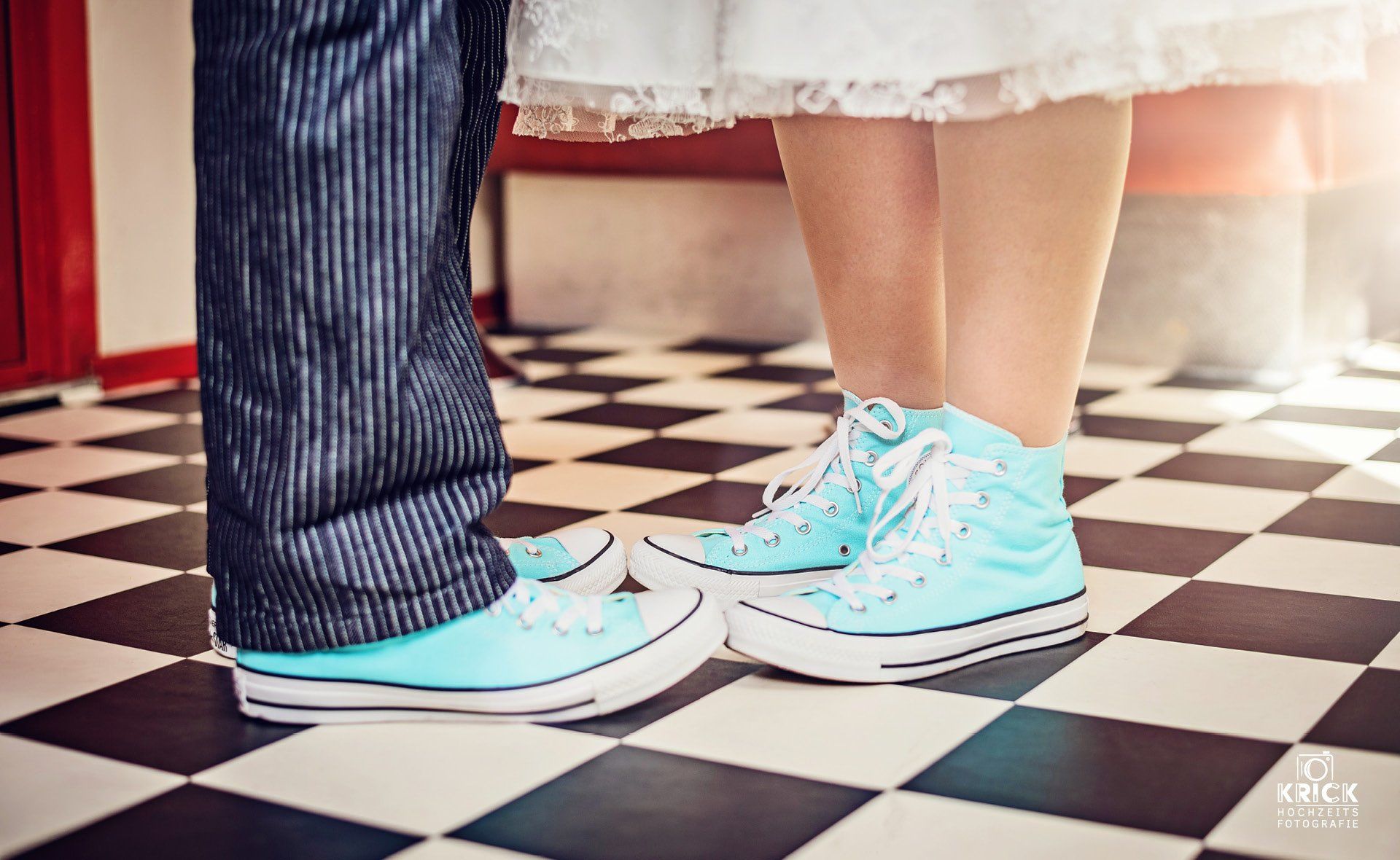 Ein Mann und eine Frau stehen nebeneinander auf einem karierten Boden.