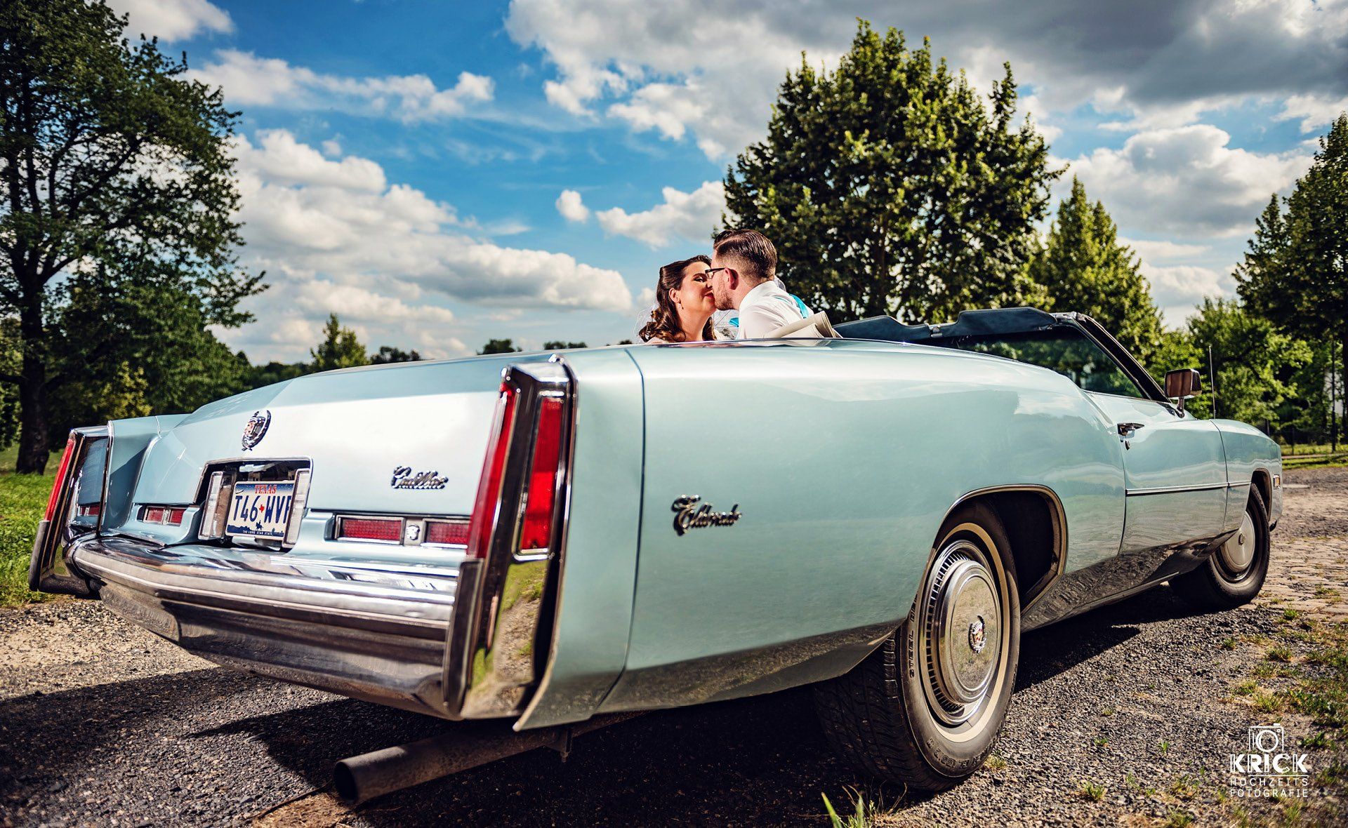 Ein Mann und eine Frau küssen sich auf dem Rücksitz eines Cadillac Cabriolets.