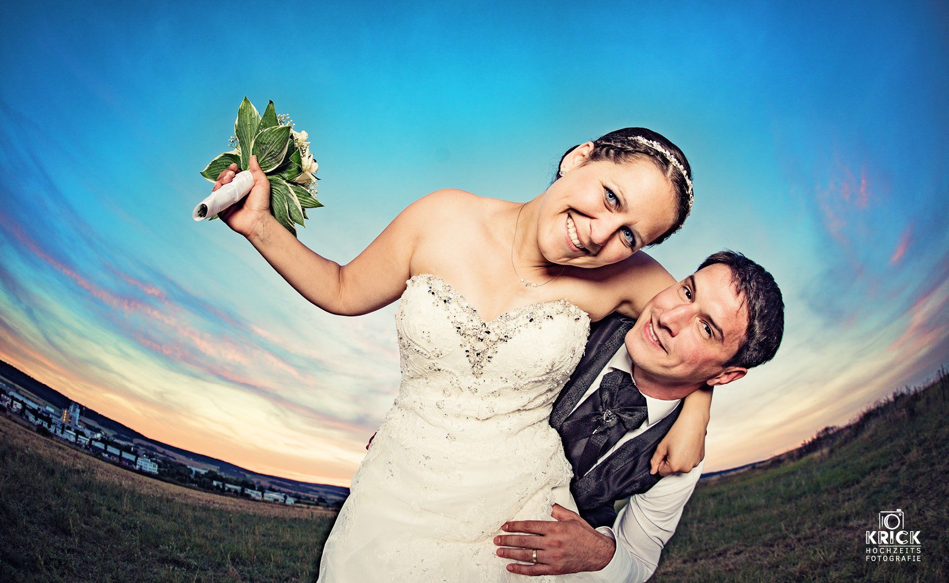 Eine Braut und ein Bräutigam posieren für ein Foto, während die Braut einen Blumenstrauß hält.