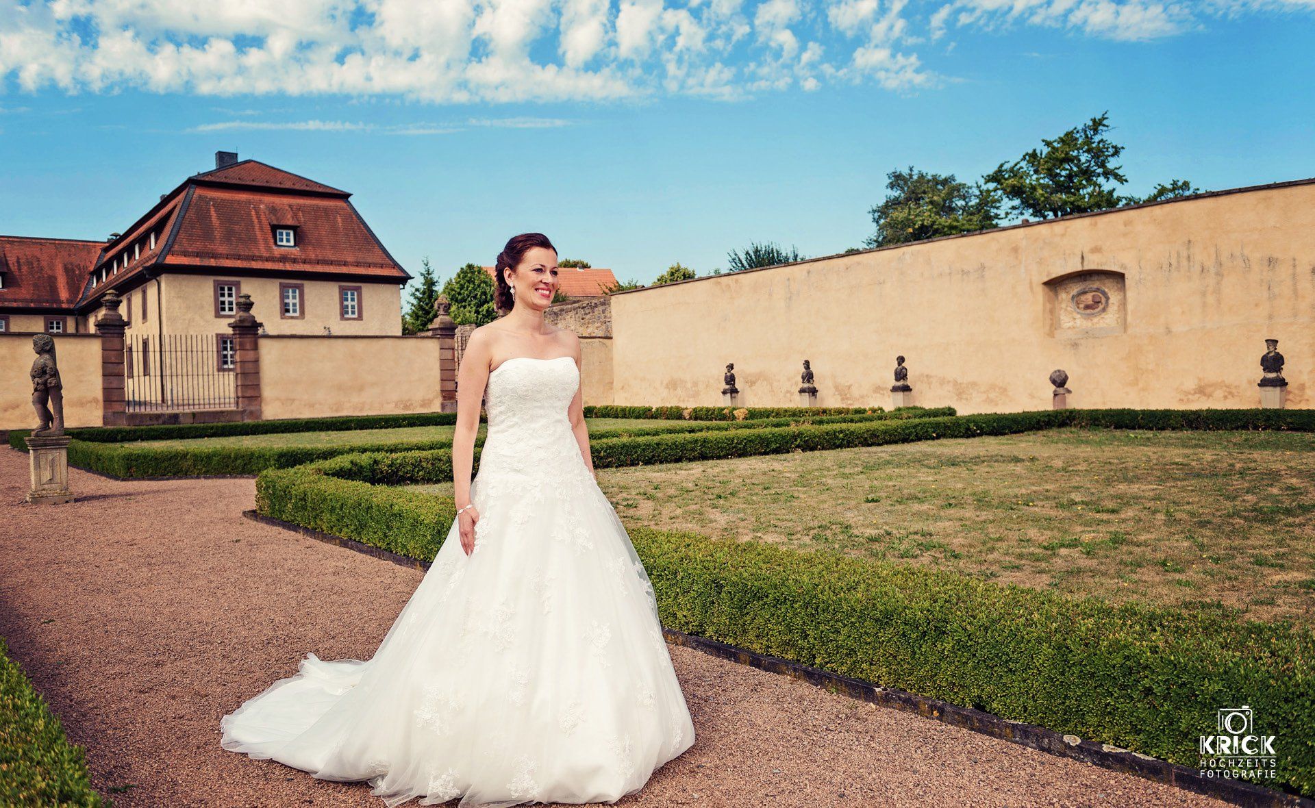 Eine Frau in einem Brautkleid steht vor einem Gebäude.