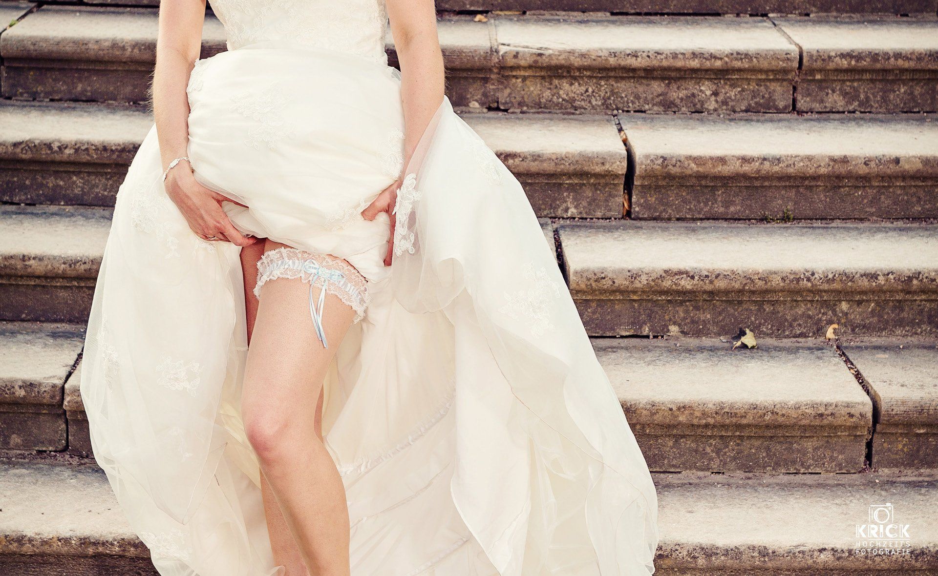 Eine Frau in einem Brautkleid steht auf einer Treppe.
