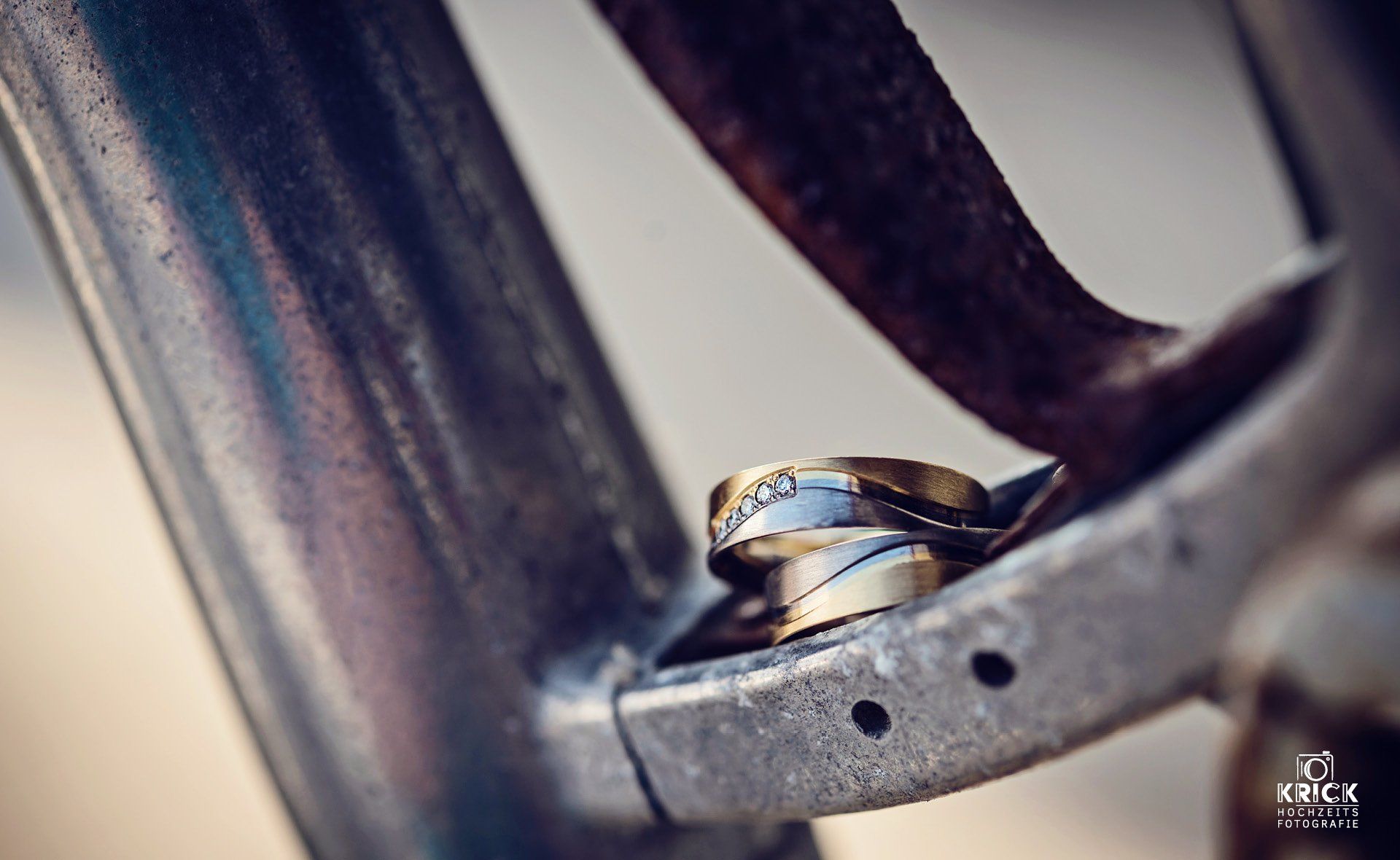 Ein Paar Eheringe liegt auf einem Metallgegenstand.