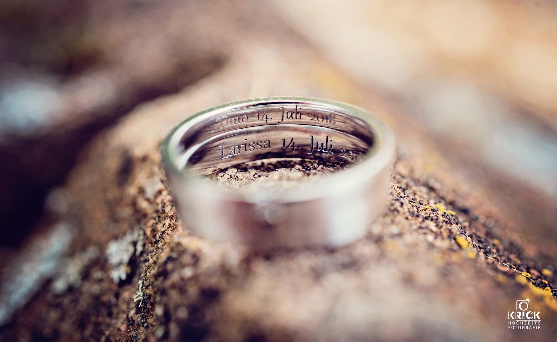 Ein Ehering liegt auf einem Stück Holz.