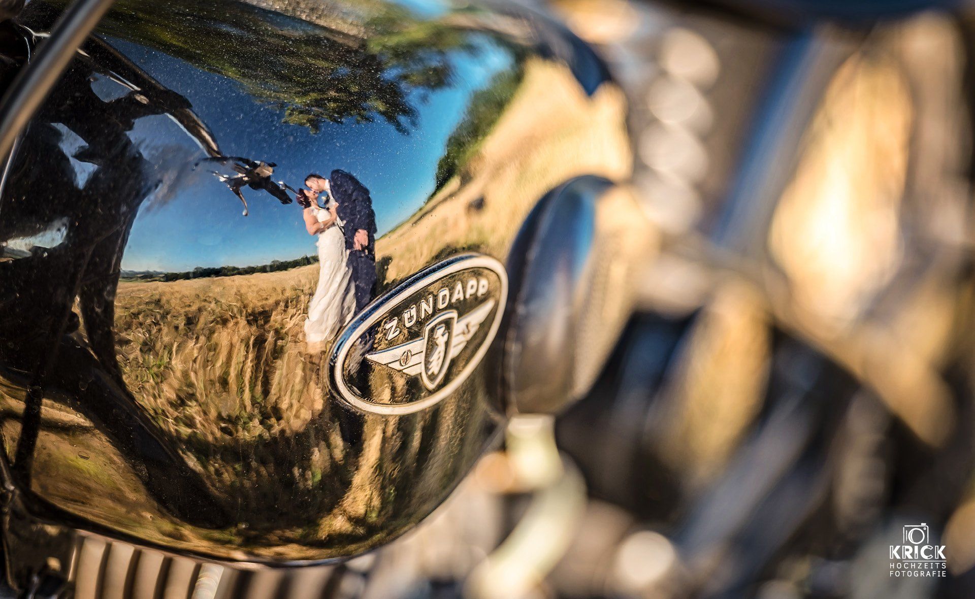 Eine Nahaufnahme eines Motorrads mit der Spiegelung einer Person im Tank.