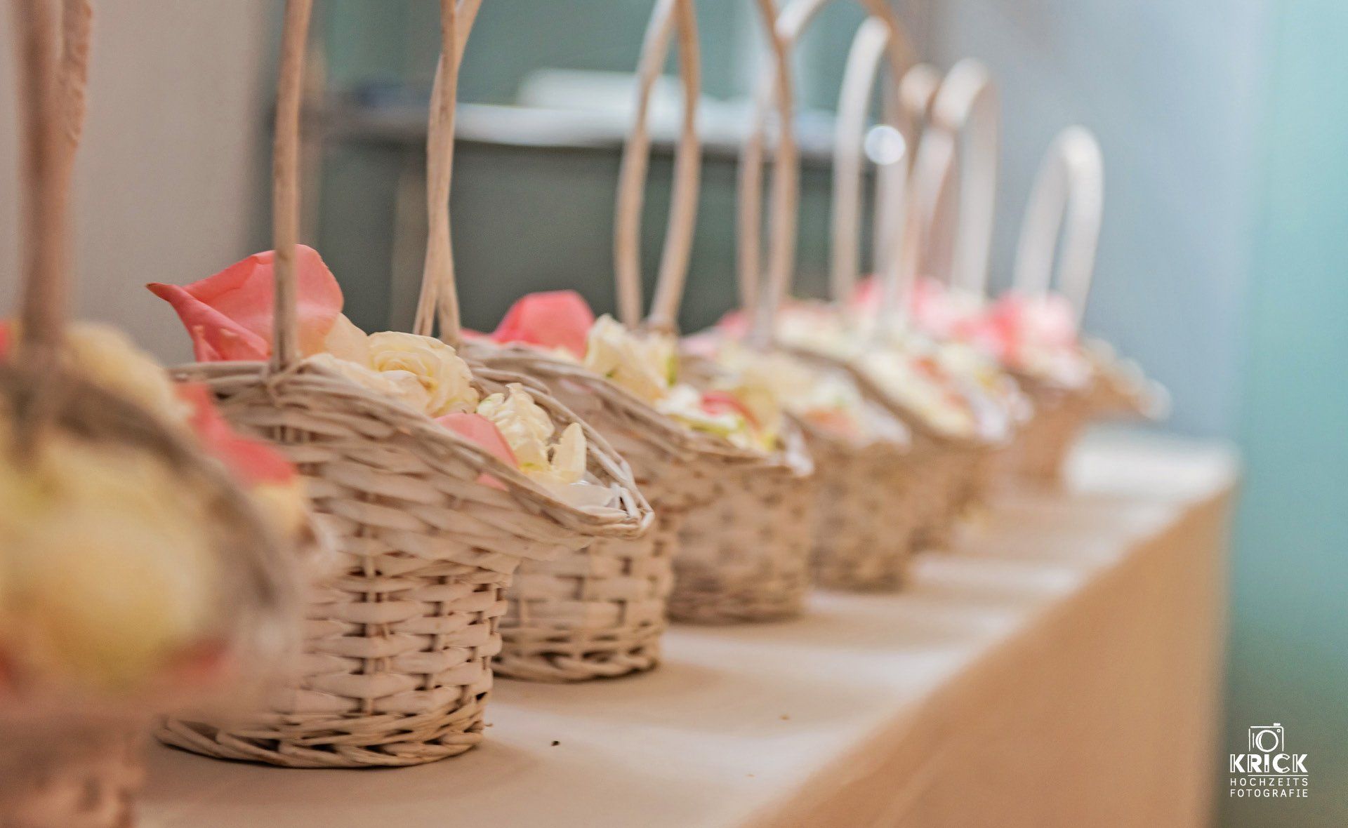 Auf einem Tisch stehen mehrere mit Blumen gefüllte Körbe.