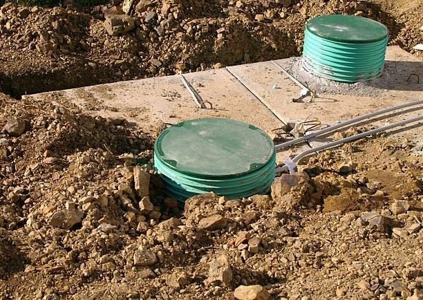 A couple of green pipes are sitting in the dirt.
