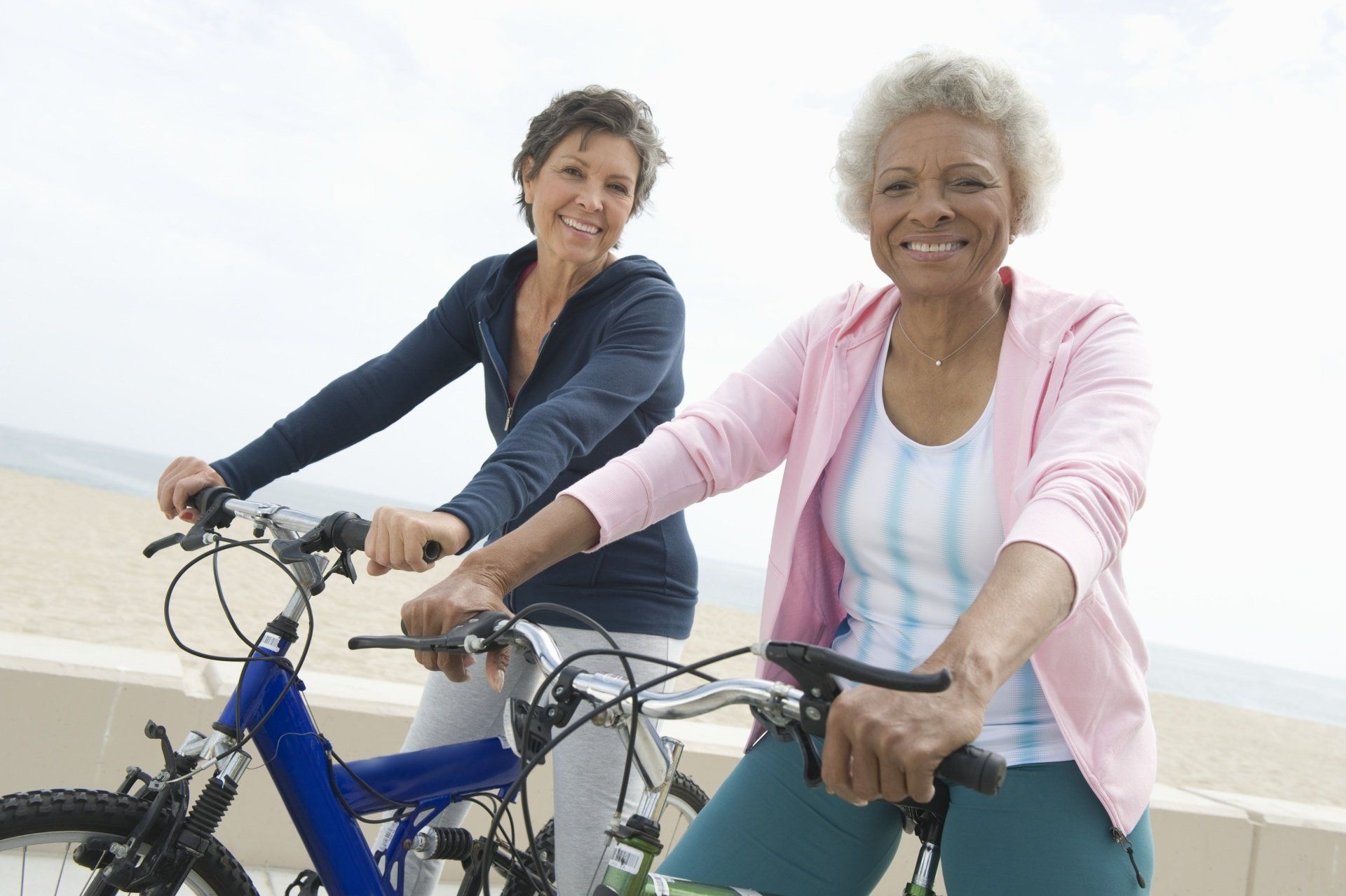 two seniors riding a bicicle and smiling