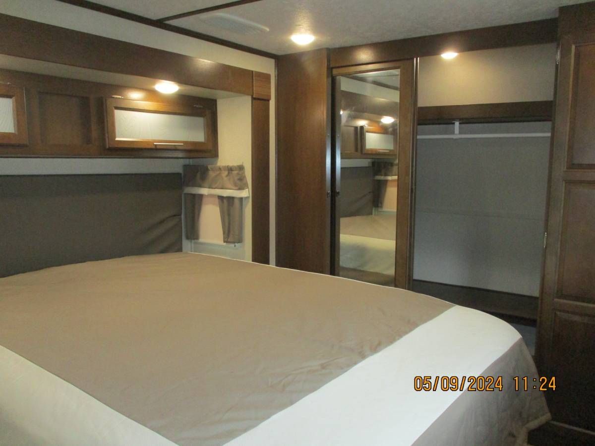 A bedroom with a king size bed and a mirror