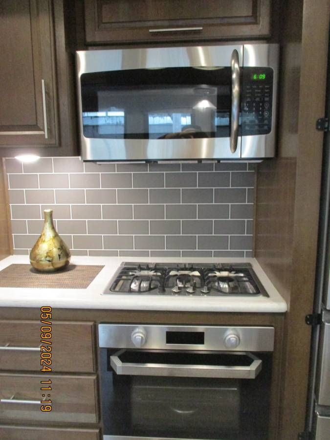 A kitchen with a stove top oven and a microwave