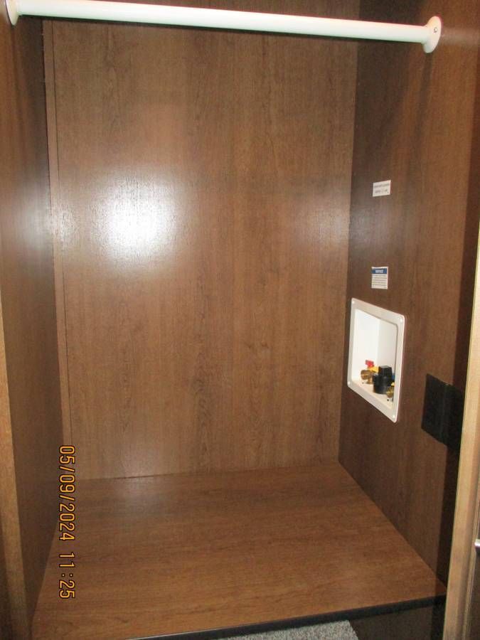 An empty closet with a hanging rail and a shelf.