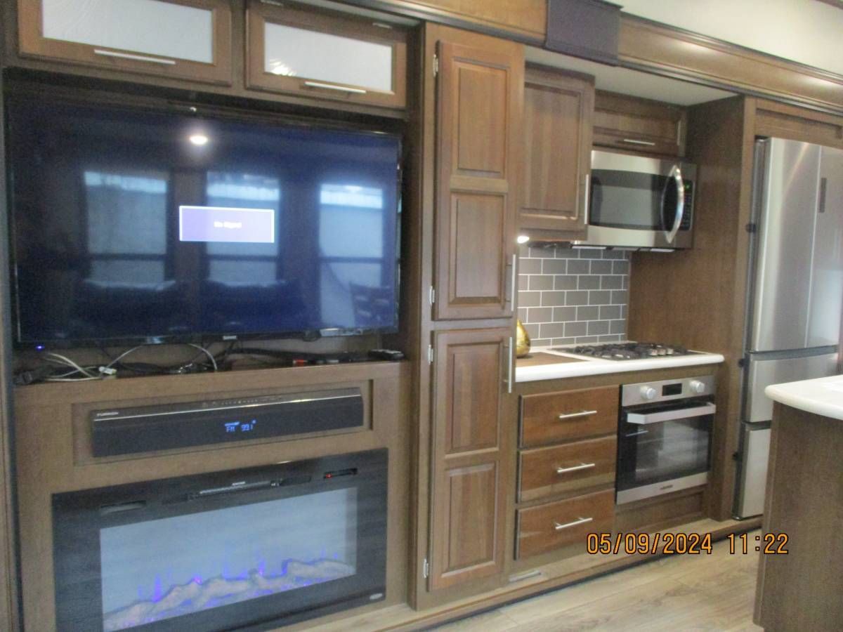 A kitchen with a flat screen tv and a fireplace.