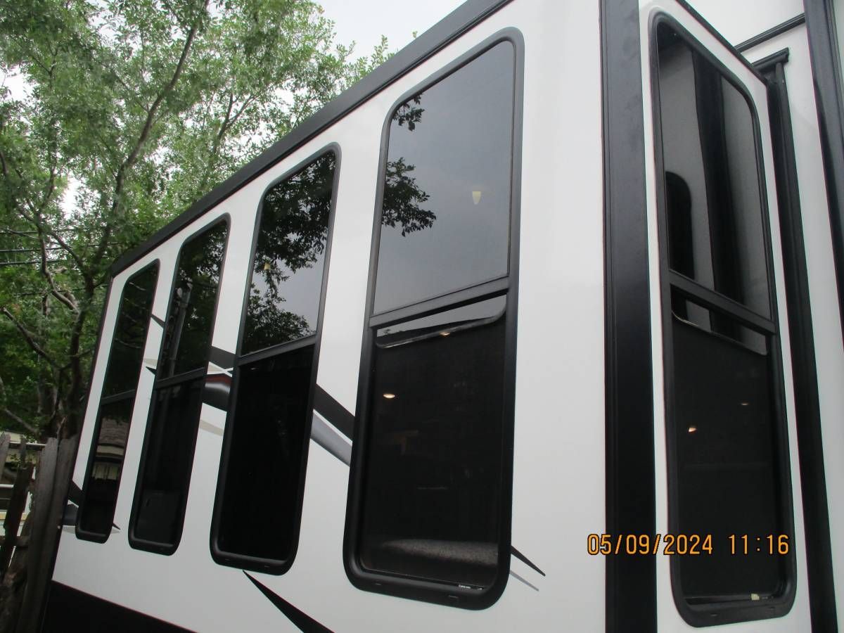 A white and black rv with a lot of windows
