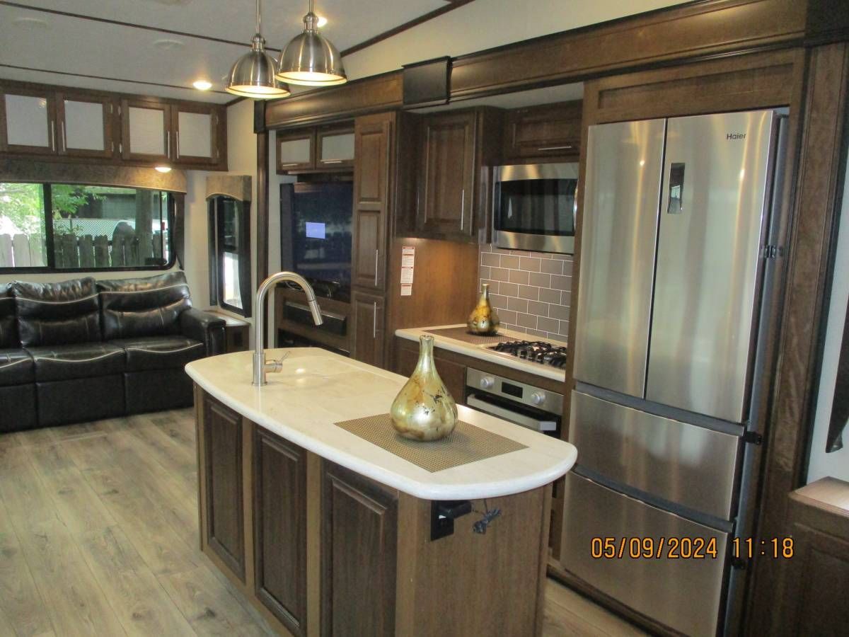 A kitchen in a rv with stainless steel appliances and a large island.