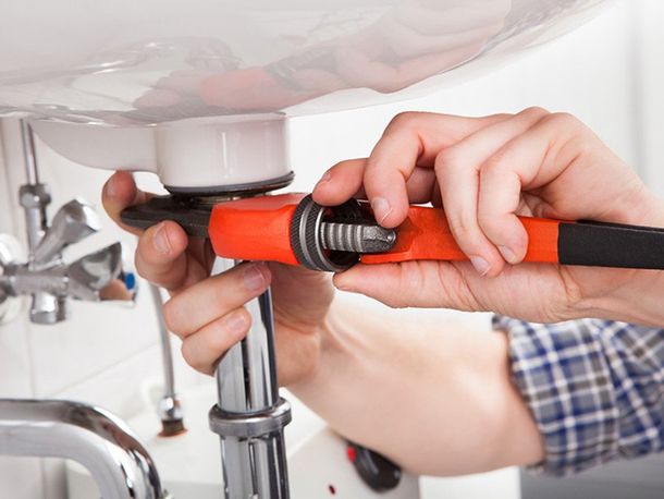 Toilet Repair/Replacement — Plumber Fixing a Sink in Bathroom in Tulare, CA