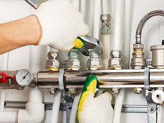 Storage Water Heaters — Worker Hands Fixing Heating System in Tulare, CA