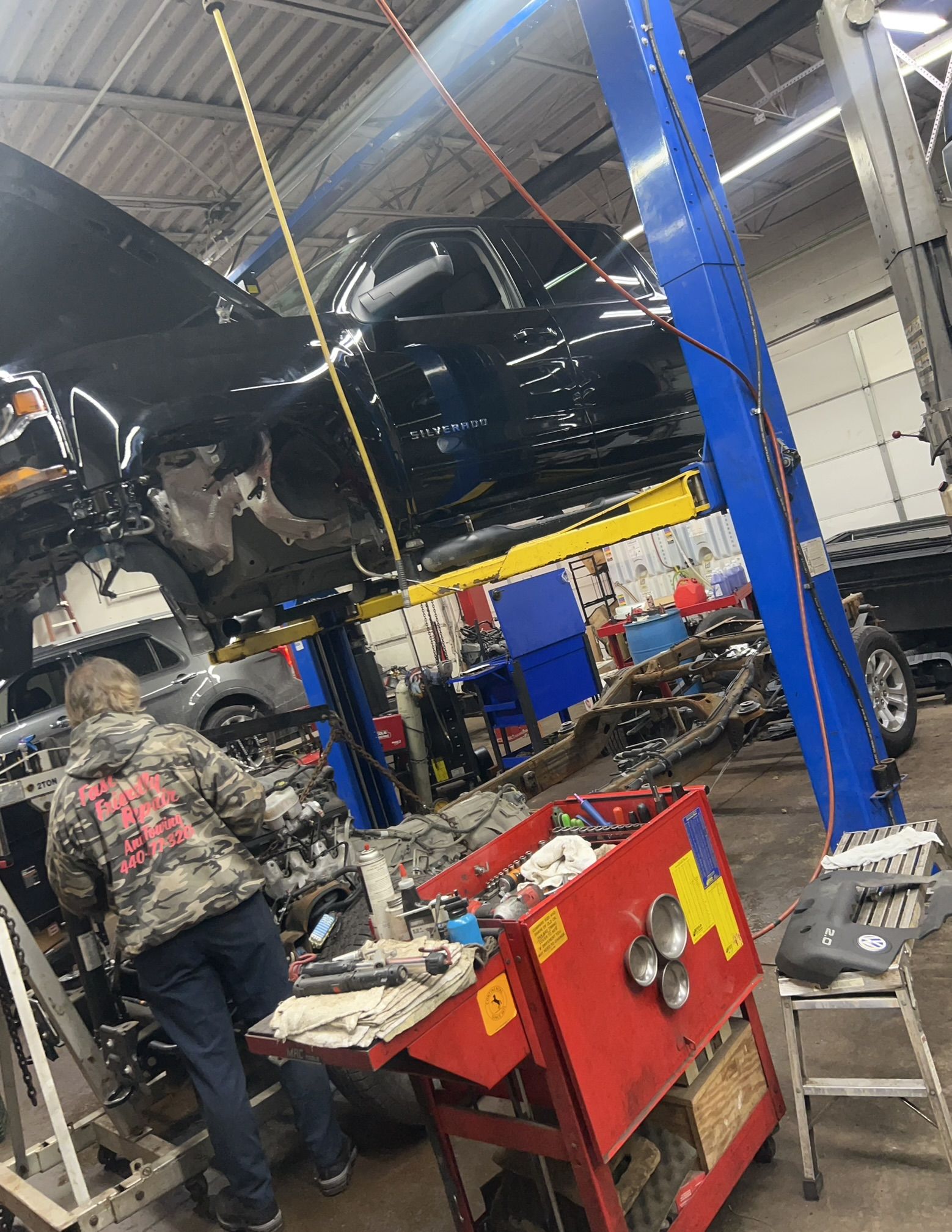 A man is working on a car in a garage.