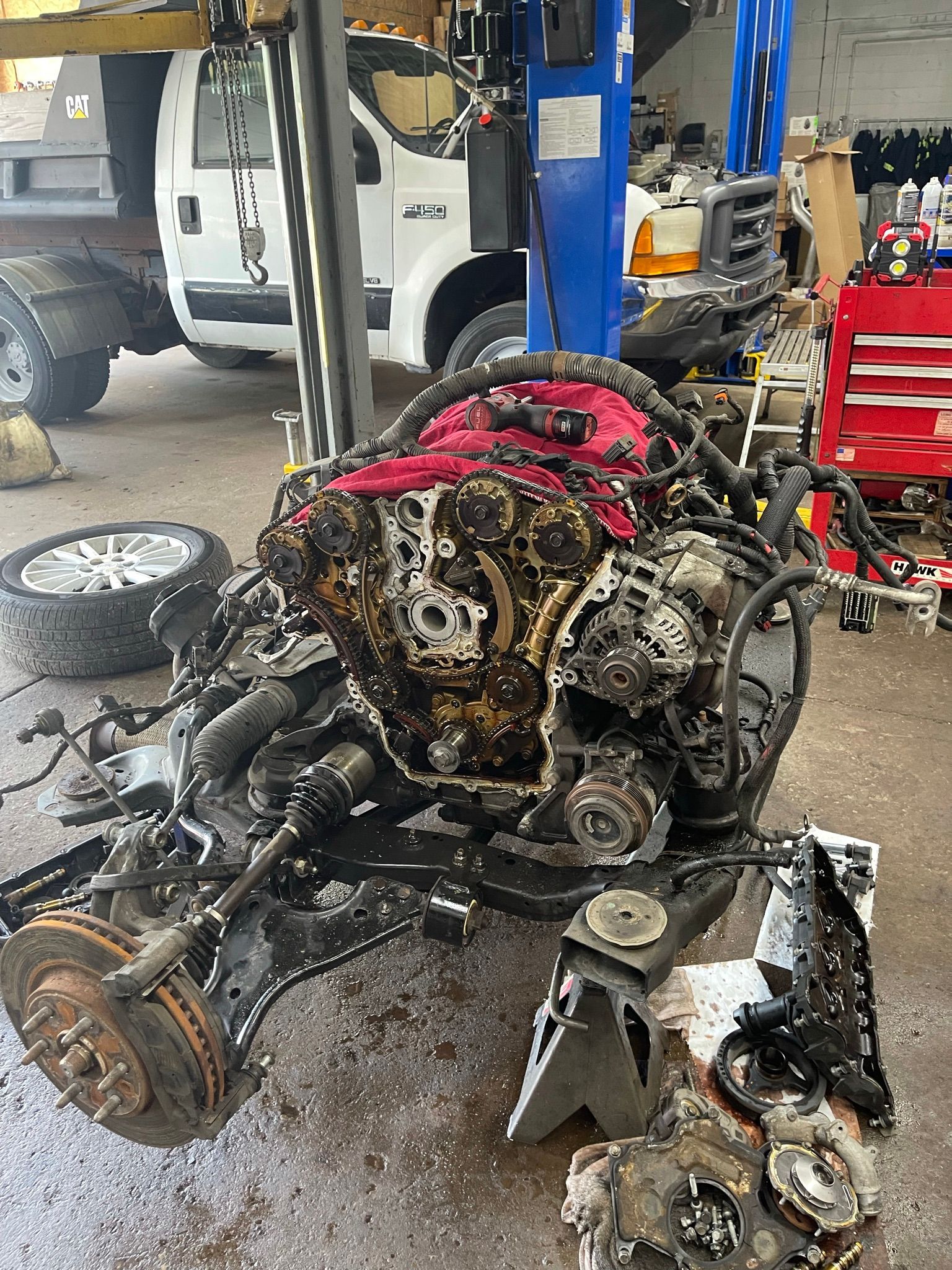 A car engine is being dismantled in a garage.