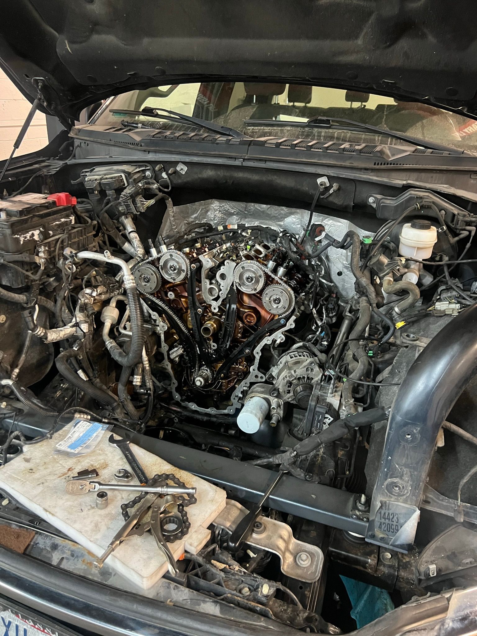 A close up of a car engine with the hood open.