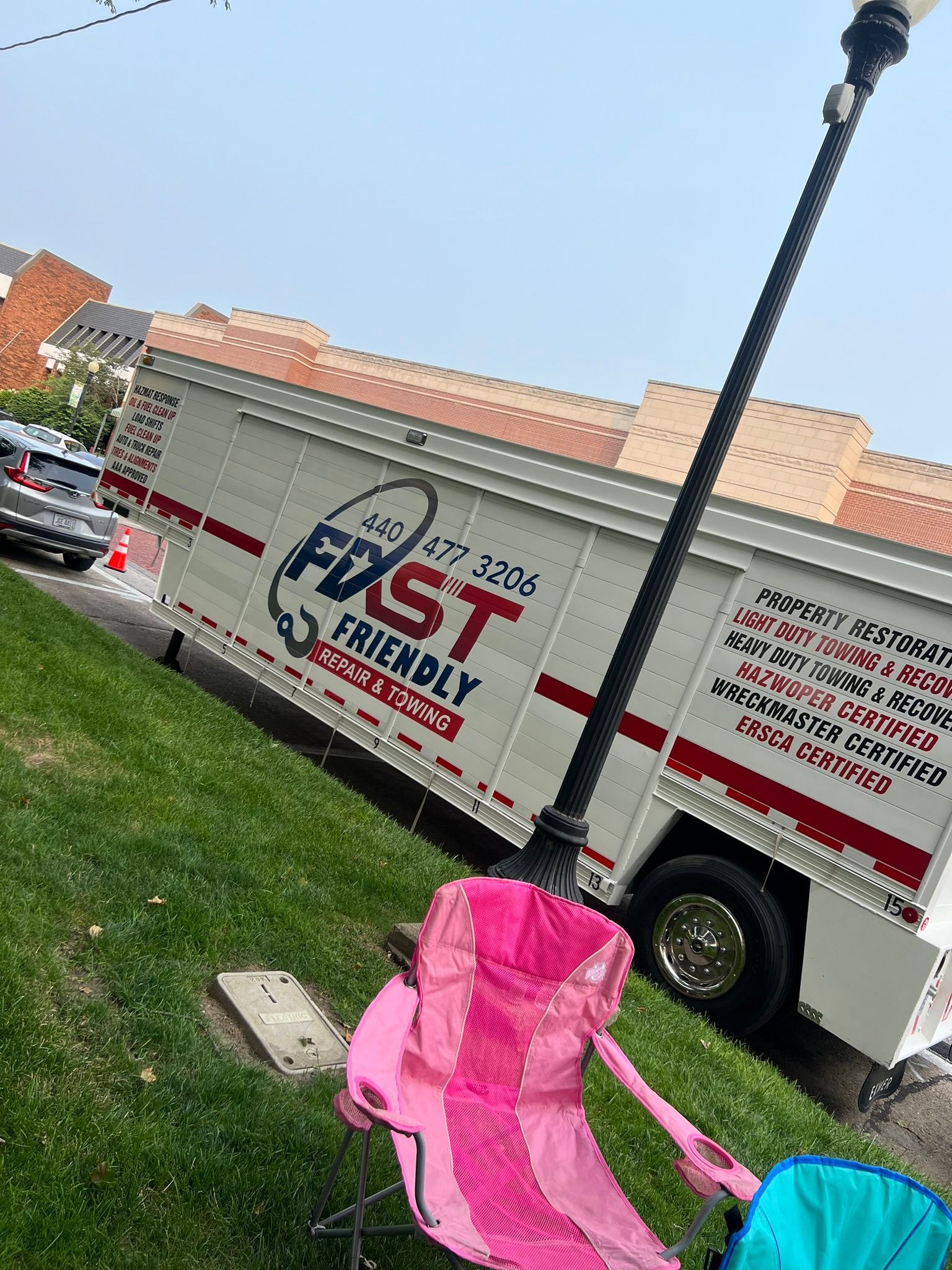 A pink chair is sitting in front of a trailer truck.