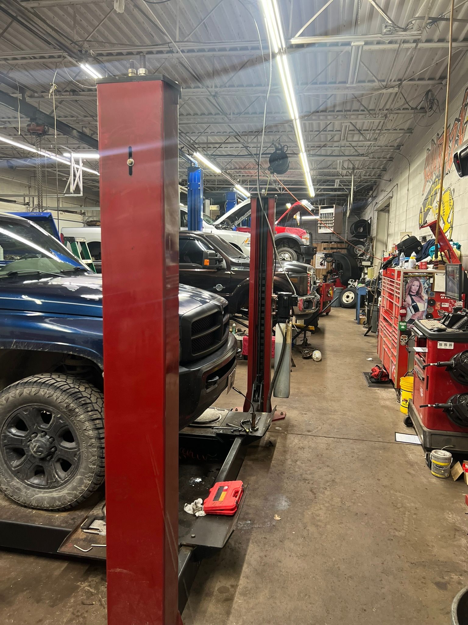 A truck is sitting on a lift in a garage.