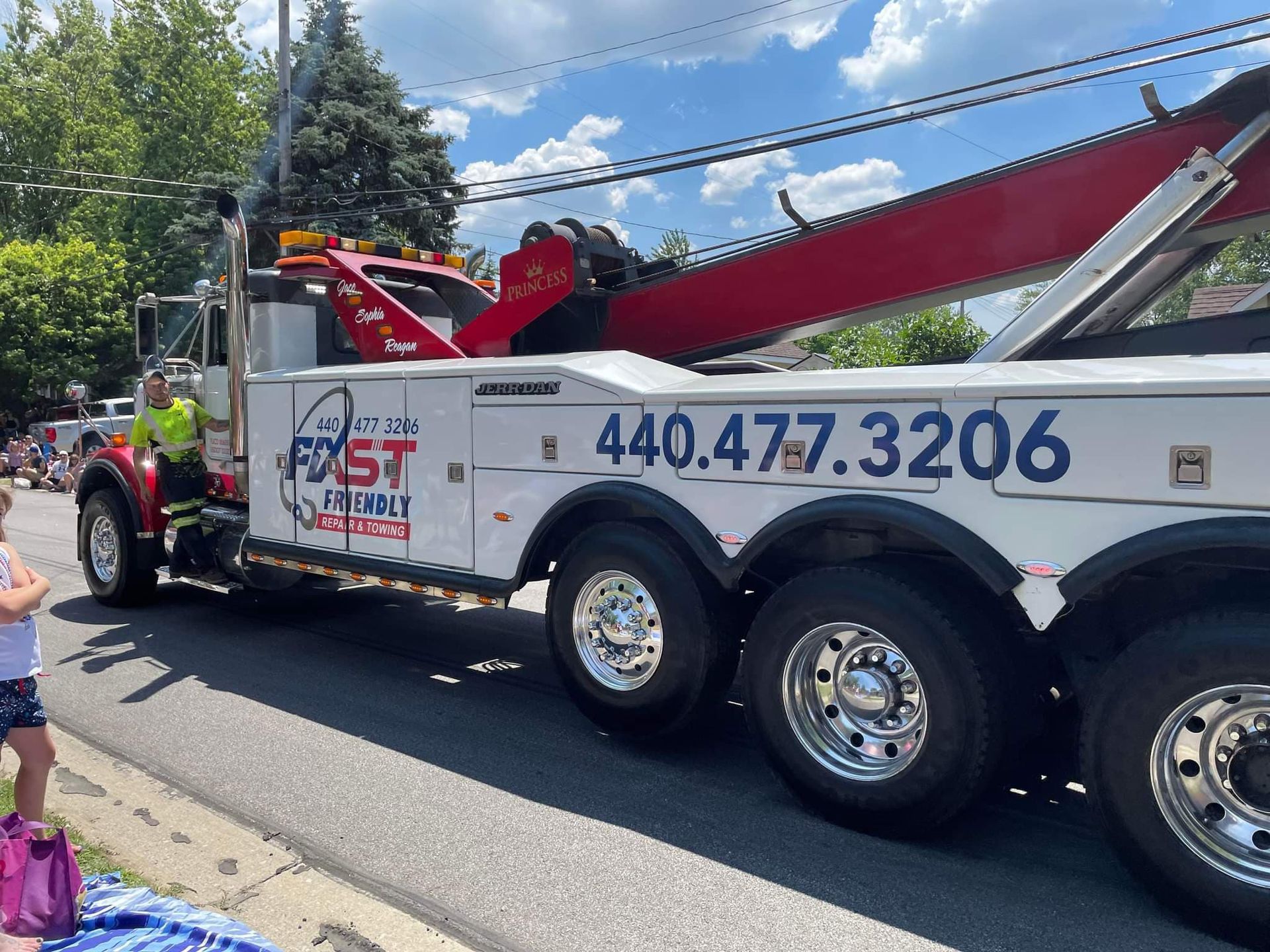 A  Fast Friendly Repair & Towing tow truck is parked on the side of the road.