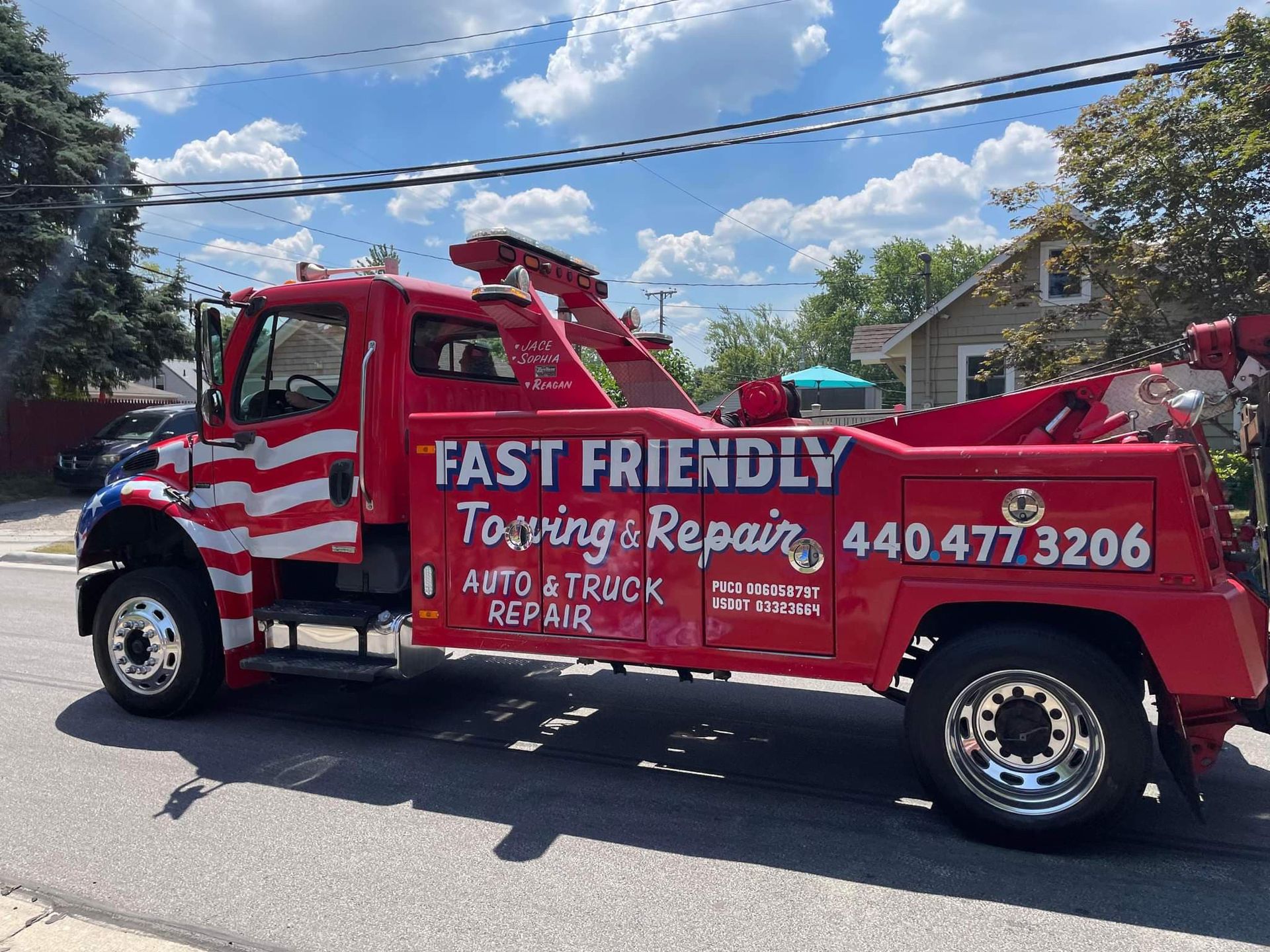 A red tow truck is parked on the side of the road.