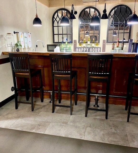 A bar with stools and a sign that says happy hour