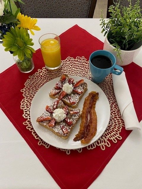 A plate of food with bacon and strawberries on it