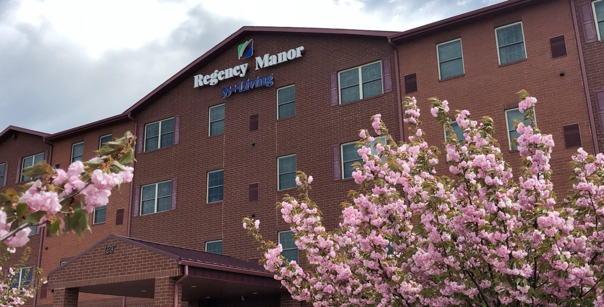 A large brick building with pink flowers in front of it