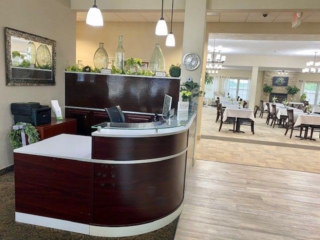 A reception desk in a restaurant with tables and chairs in the background.