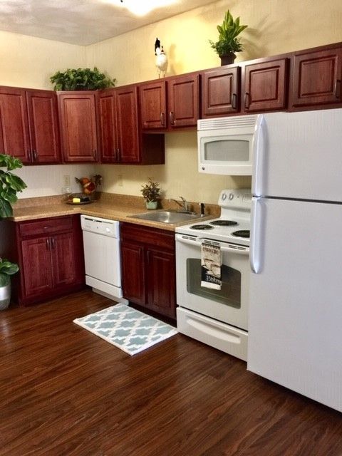 A kitchen with wooden cabinets and a white refrigerator