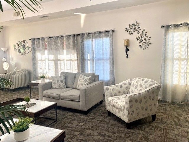 A living room with a couch and two chairs