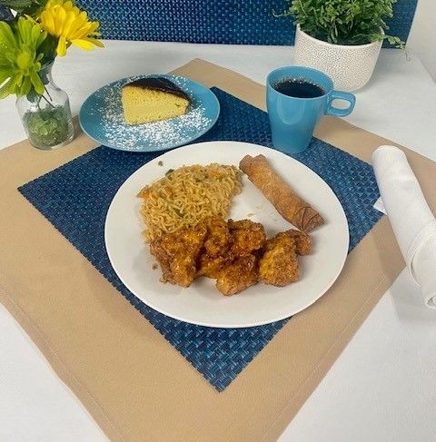 A plate of food on a table with a cup of coffee