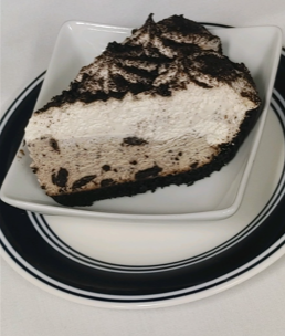 A slice of oreo pie on a white plate