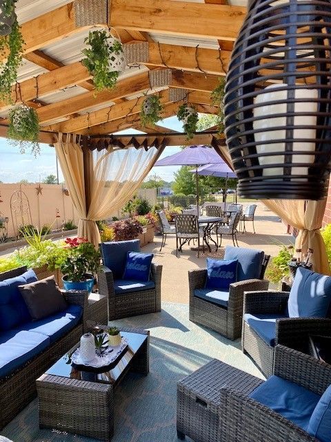 A patio with furniture and umbrellas under a canopy