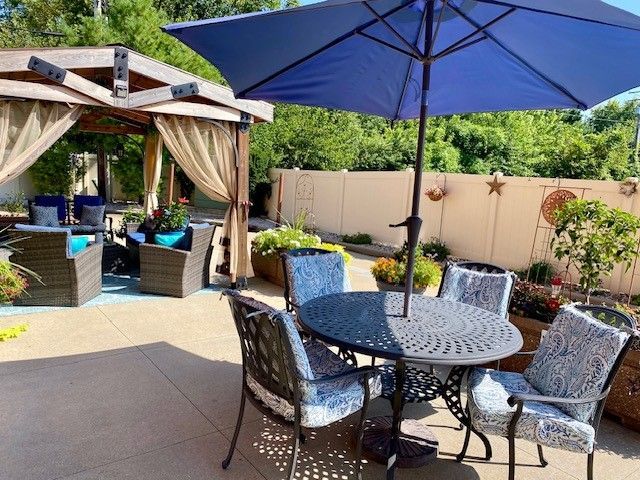 A patio with a table and chairs under an umbrella