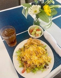 A plate of food and a glass of iced tea on a table.