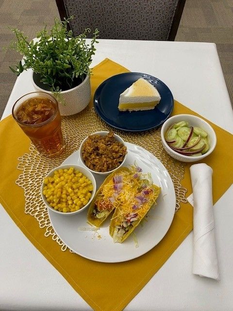 A table topped with plates of food including tacos