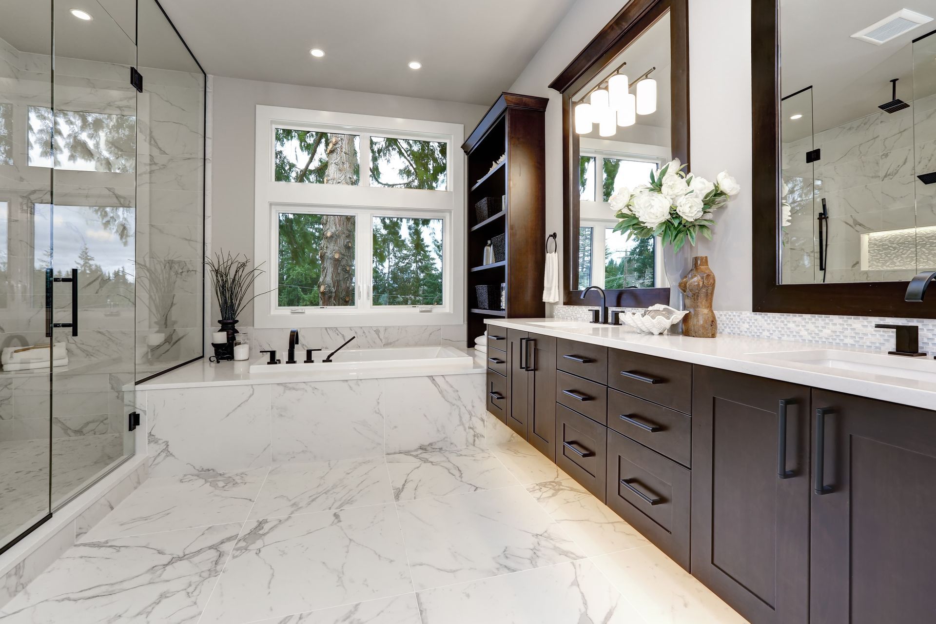 A bathroom with two sinks , a tub , and a mirror.