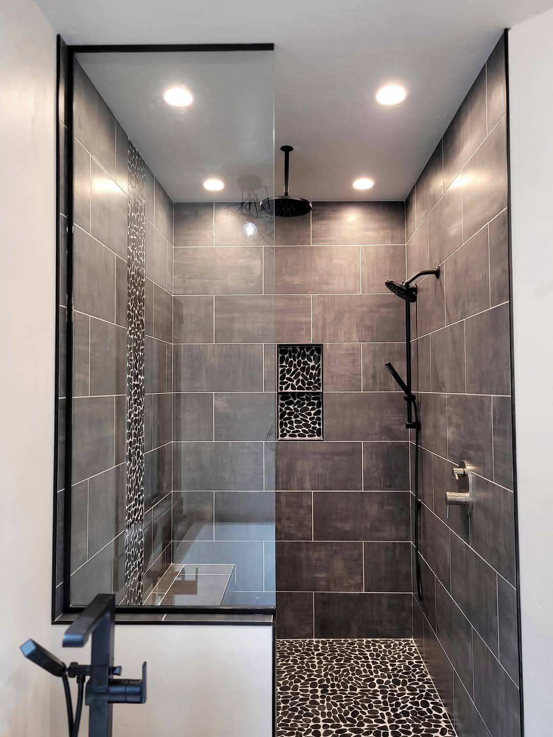 A forklift lifts a wooden beam to build a gate frame in a field with trees.