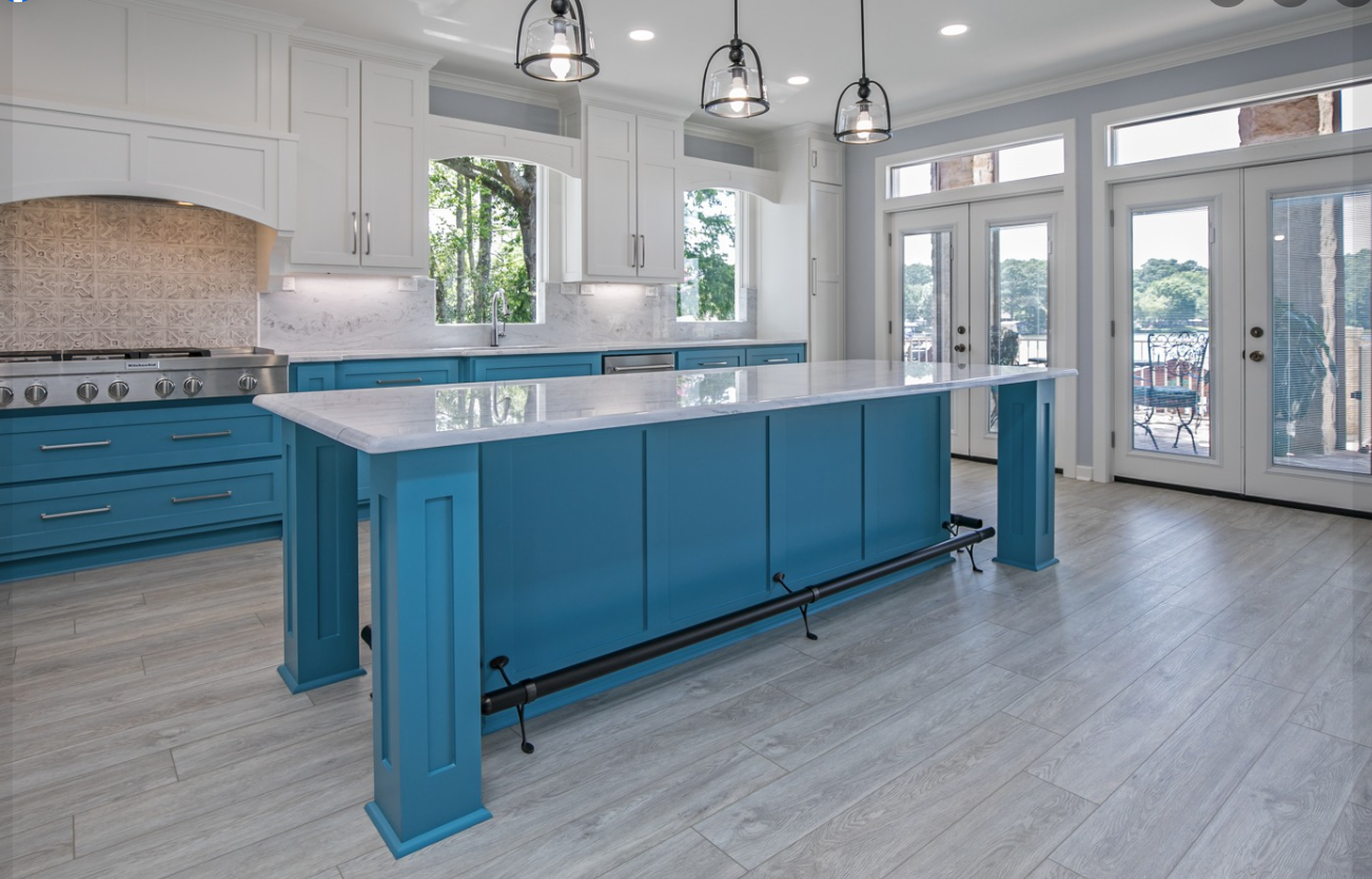 A kitchen with blue cabinets and a large island in the middle.
